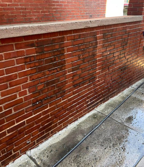 Same brick wall restored to clean red after washing